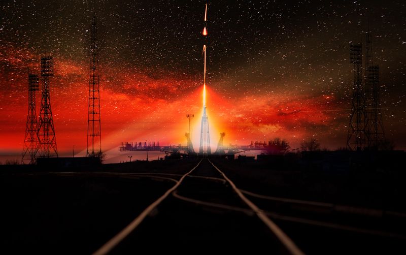 Missile launch at night. Dark sky with light flares and red sky, railway track at the first stage. The elements of this image furnished by NASA.