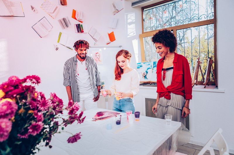 Creative couple. Creative couple feeling excited while watching woman doing marble painting