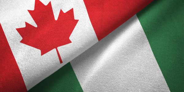 Close-up of Canadian and Nigerian flags overlapping.