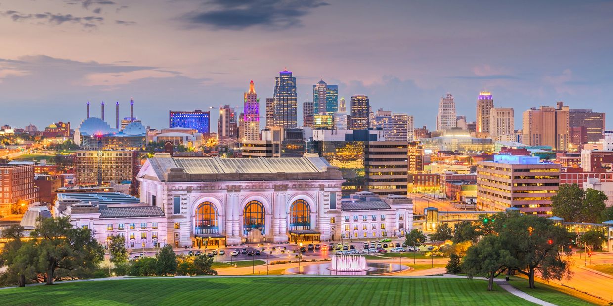 Downtown Kansas City with illuminated buildings at dusk.