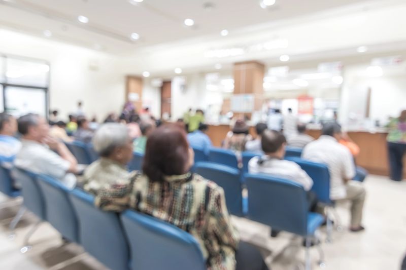 Blur medical background clinic service counter lobby with patient paying bill at cashier desk  in hospital