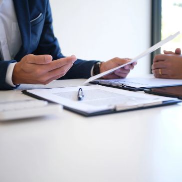 Two people discussing documents at a desk.