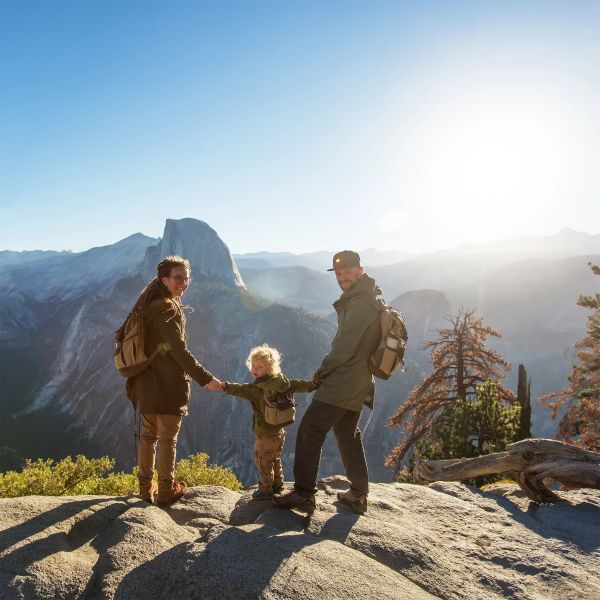 Family hiking in a mountainous landscape during sunrise or sunset.