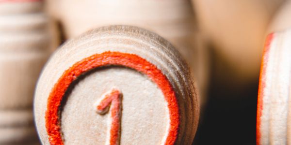 Close-up of a wooden game piece marked with number 1 in red.