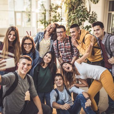 Group of happy young friends taking a selfie indoors.