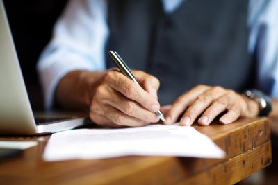 Person writing on a paper at a desk.
