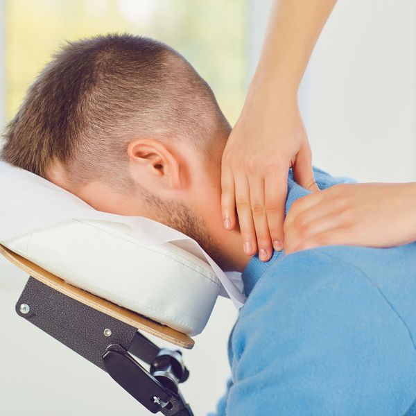 Man receiving a neck massage while resting on a massage chair.