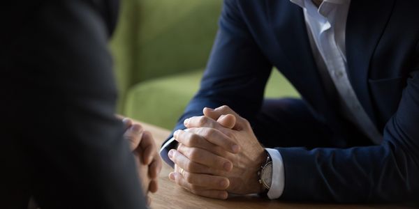 Close-up of hands clasped during a business meeting.