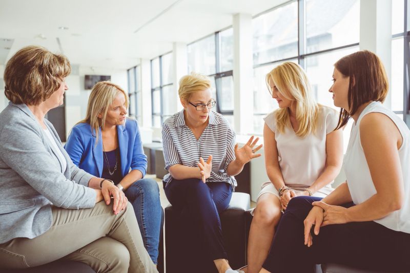 Group of women brainstorming during a training session. Mentor guiding group of women in a training.