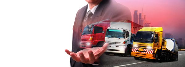 Businessman presenting transportation trucks with city backdrop.