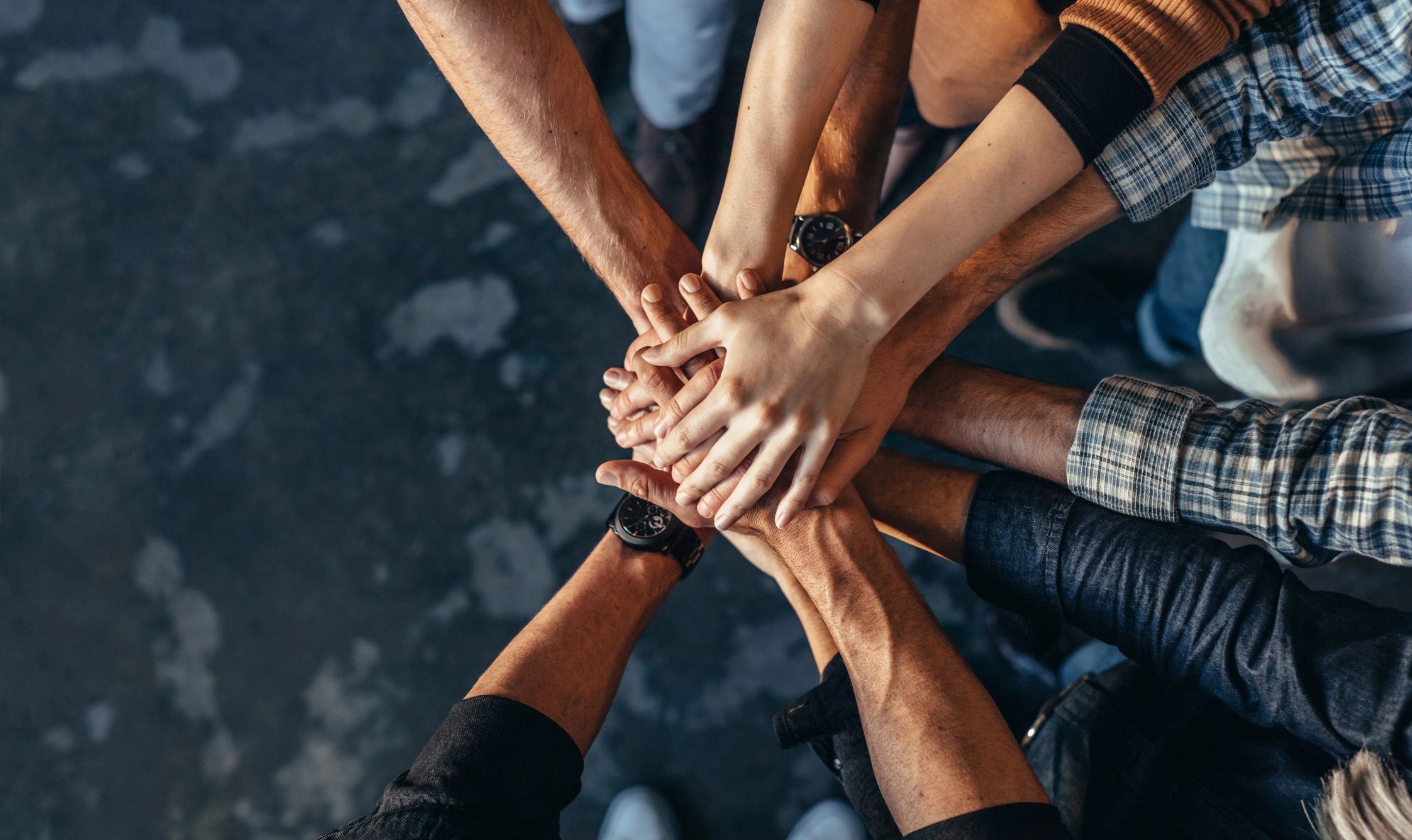 Hands stacked together in a team gesture.