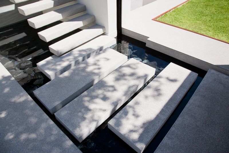 Floating stairs over outdoor pond in backyard