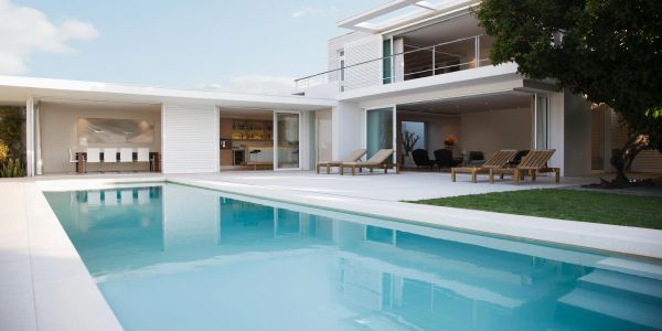 Modern house with a pool and lounge chairs.