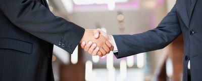 Two people shaking hands in business suits.