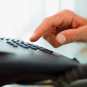 Hand dialing a phone keypad.