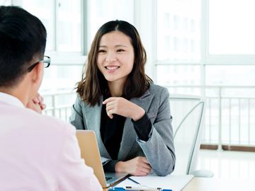 Professional woman smiling in a business meeting with a colleague.