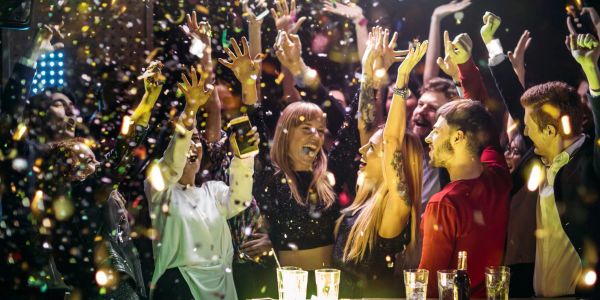 Personas celebrando con confeti en una fiesta animada.