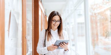 Woman using a tablet and smiling.