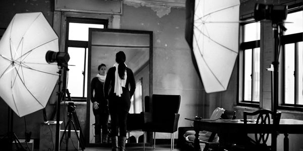Woman standing in front of a mirror in a photography studio.