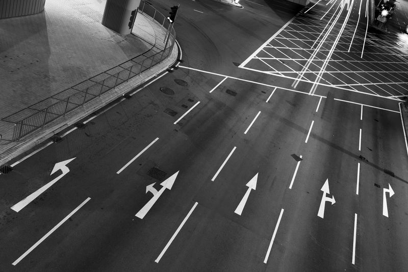 White arrow sign painted on black asphalt