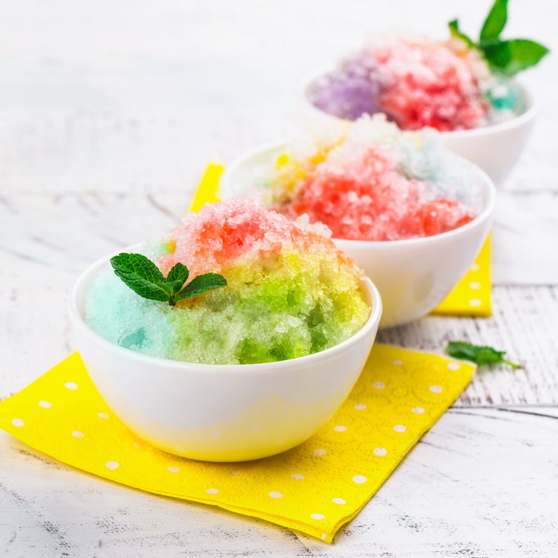 Homemade rainbow shaved ice on white background