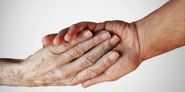 Hands of two people holding each other.