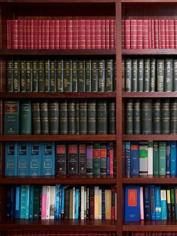 A bookshelf filled with organized legal and academic books of various colors.
