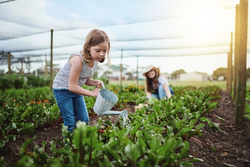 Full length shot of a young mother and her little daughter working on the family farm