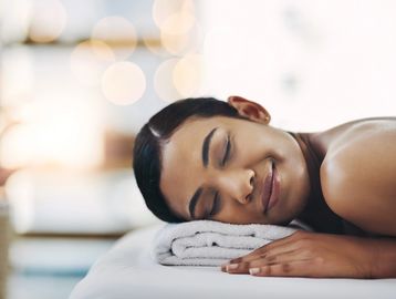Woman relaxing on a spa bed after a Brazilian wax in Everett, WA at Autumn Noel Esthetics. 