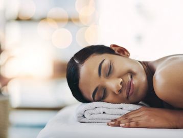Woman relaxing on a spa bed after a Brazilian wax in Everett, WA at Autumn Noel Esthetics. 