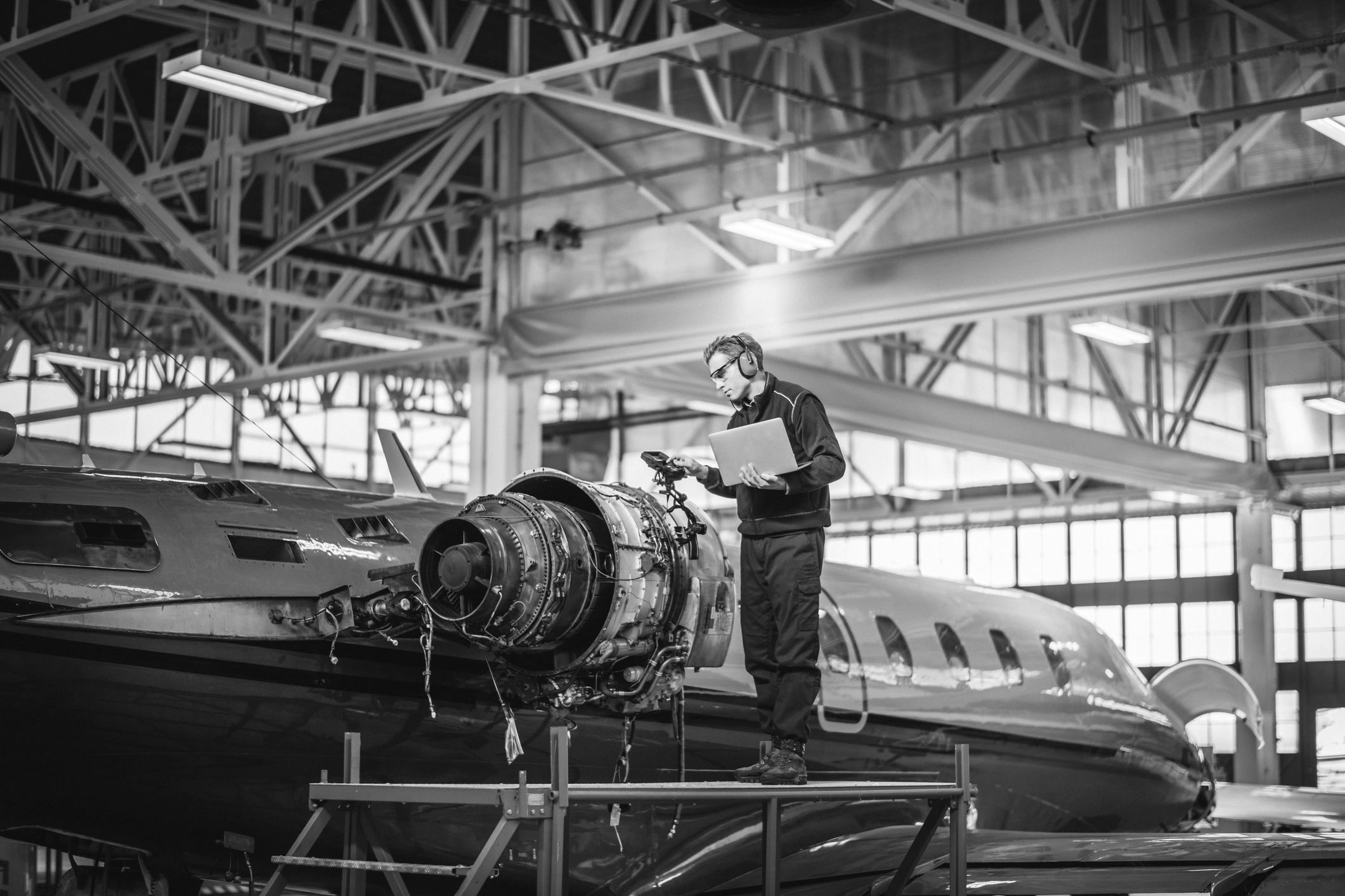An engineer inspecting an aircraft engine in a hangar, the kind of supplier CMMC Level 2 applies to