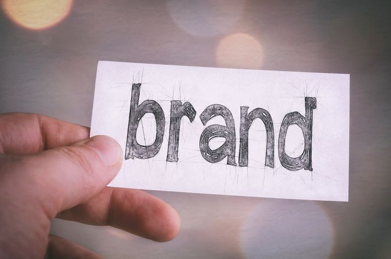 Create your Brand. Businessman shows Brand card. Brand awareness improvement concept.