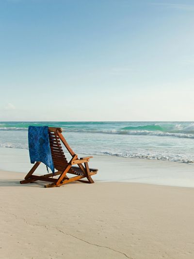 Empty chair by the ocean represents the loneliness witnessed in childhood emotional neglect therapy.