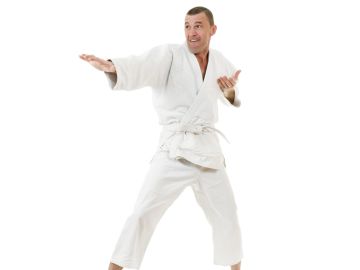 Man in white martial arts uniform performing a karate stance.