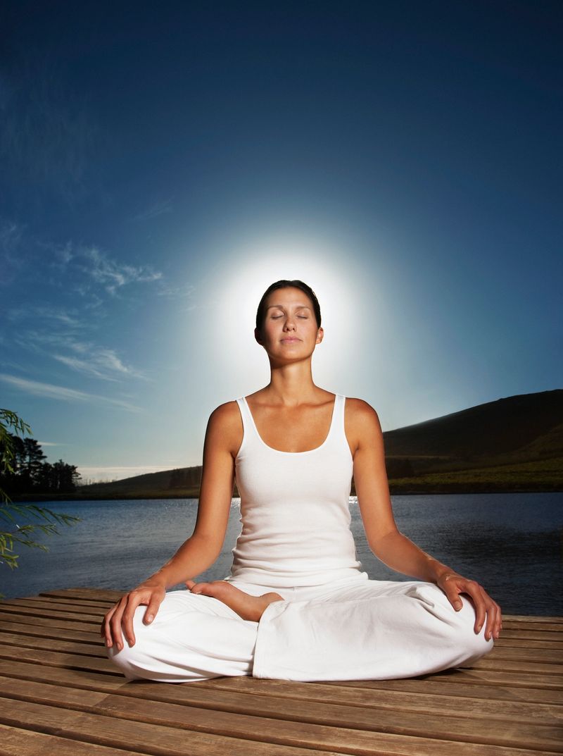 Woman practicing yoga on pier