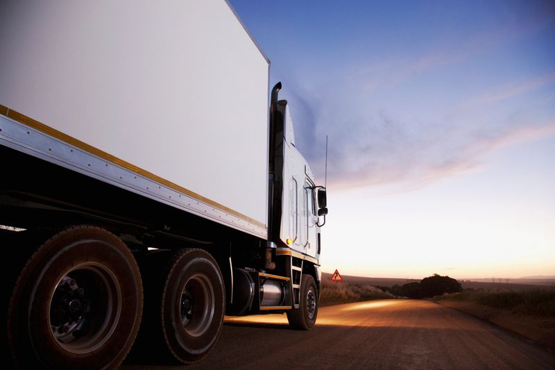 Semi-truck driving on dirt road