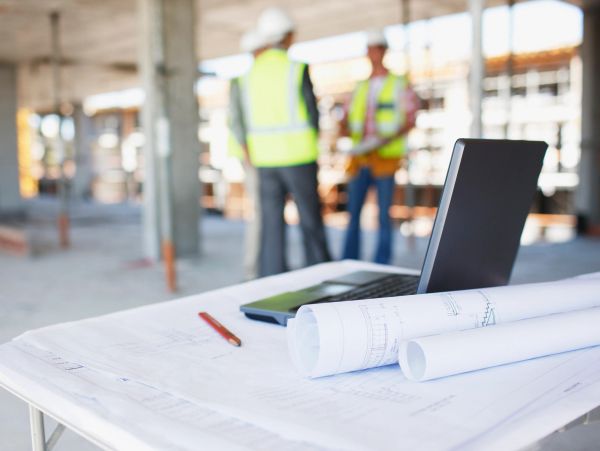 Construction site with blueprints and laptop.