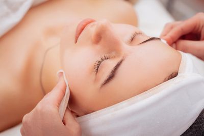 A woman enjoying a relaxing facial treatment with closed eyes.