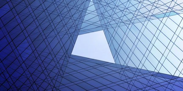 Abstract upward view of a blue glass building with geometric lines.