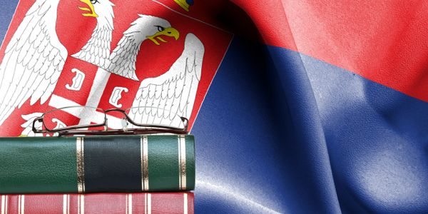 Stack of books and glasses on the Serbian flag.