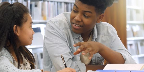 Two students engaged in a conversation while studying.