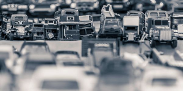 Black and white photo of toy vehicles arranged in rows.