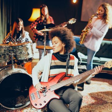 Young women jamming with musical instruments.
