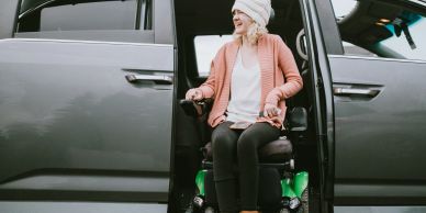Woman using a wheelchair exit from a vehicle.