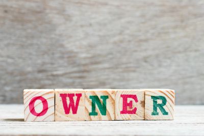 Wooden blocks spelling 'OWNER'.