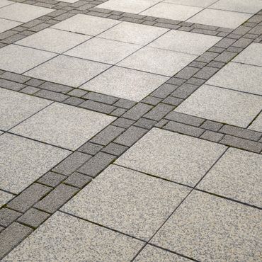 Close-up of patterned stone pavement with intersecting dark brick lines.