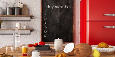 A cozy kitchen counter with breakfast items and an empty chalkboard for ingredients.