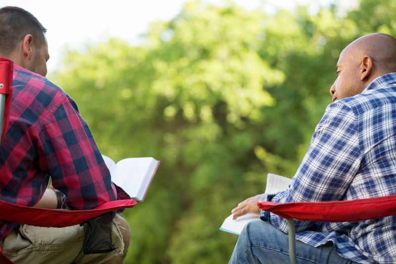 Men having a bible study on a camping trip.