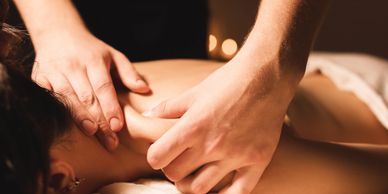 Person receiving a relaxing shoulder and neck massage in a calm setting.