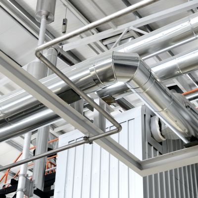Industrial metal air ducts and pipes inside a building.